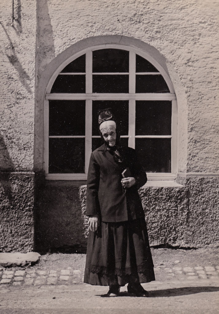 Alte Frau in Tracht vor dem Haus Fürst, ca. 1950-1952