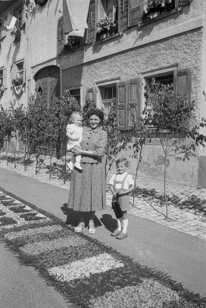 Frau mit zwei Kindern in der Vorstadtstraße, Fronleichnam 1958