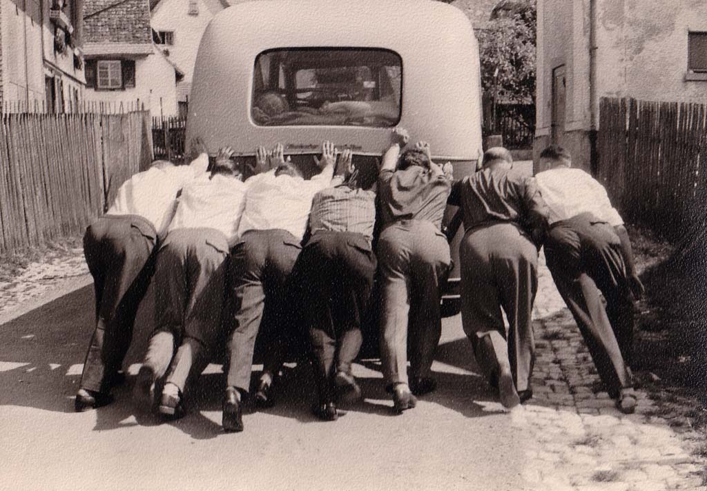 Männer beim Anschieben eines Busses in der Bittengasse, 1961