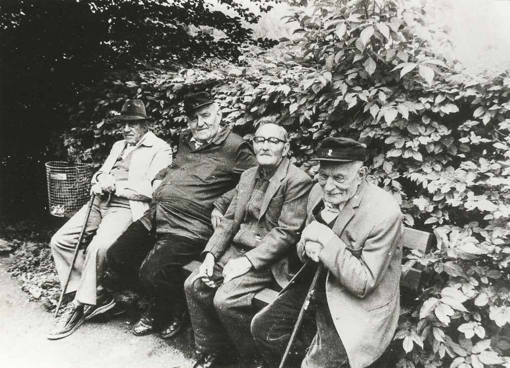 Vier Männer auf einer Sitzbank, 1985